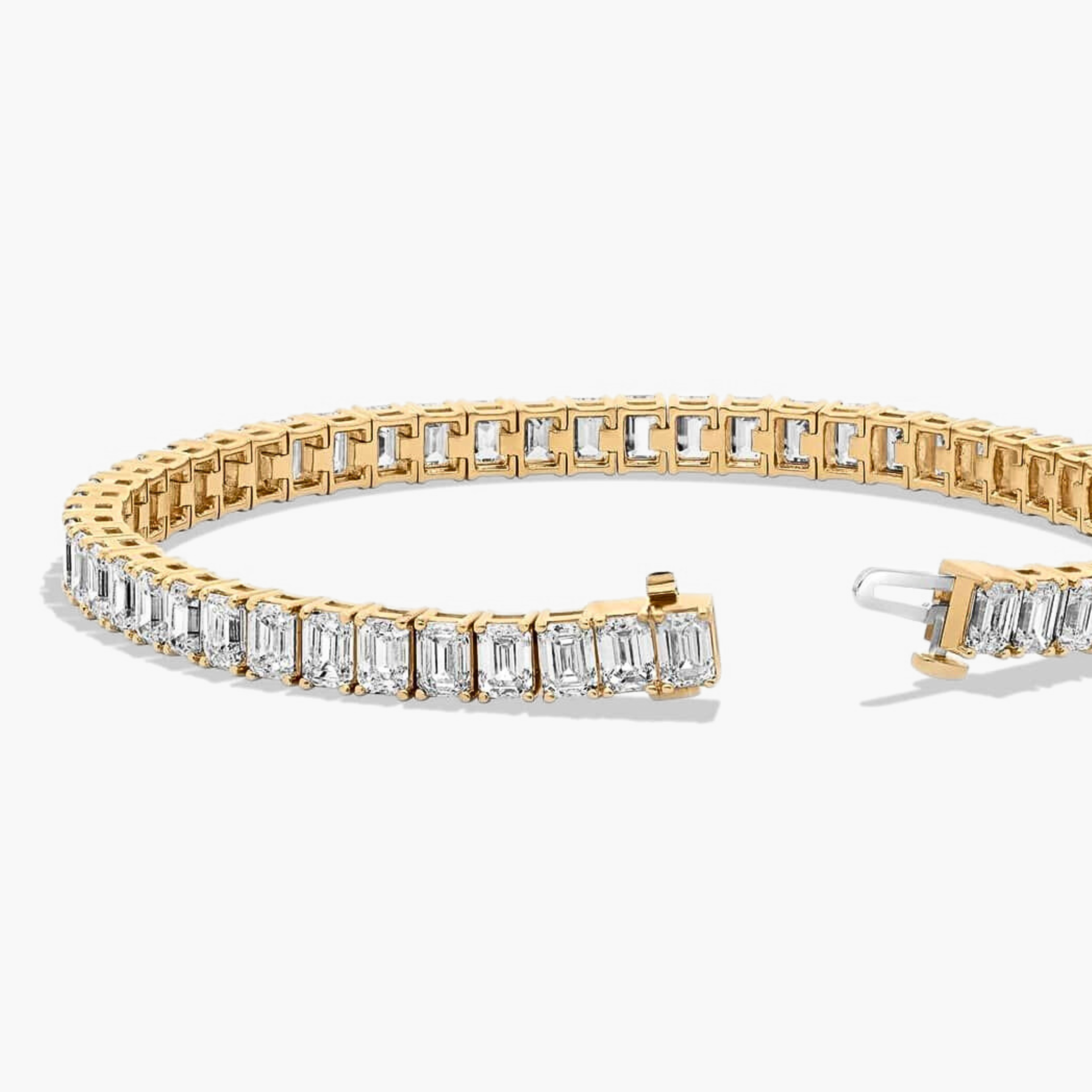 Emerald cut diamond tennis bracelet with open clasp in yellow gold